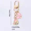 Gold tone alloy keychain featuring pink enamel butterfly and pearl round flower pendant charms. - Round Butterfly / Pink