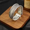 Closeup of silver metal multi-strand open cuff bracelet, geometric layered jewelry detail. - Silver