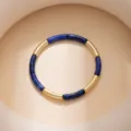 Close-up detail of a fashion leopard print and gold-tone metal geometric linked bracelet. - Blue