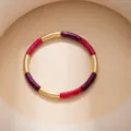 Detailed shot of a chic color-blocked bracelet featuring gold metal tubes and leopard print resin. - Purple