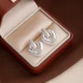 Detailed view of vintage textured diamond rhombus earrings, elegant metal geometric design. - Silver