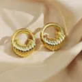 Gold plated chunky ribbed hoop earrings detail shot showing geometric texture and luxury design. - Gold