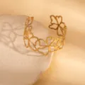 Gold-plated metal open cuff bracelet with hollow floral cutout design, chic and retro style for women. - Hollow-Out Floral Style / Gold