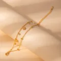 Close-up of a stylish double-layer gold stainless steel bracelet with delicate flower charms. - S795