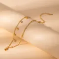 Detailed close-up of gold-plated stainless steel anchor charm bracelet with crystal accents. - S804