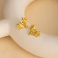 Detail view of vintage metallic flower stud earrings, unique artistic design, glowing golden finish. - E4772