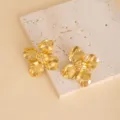 Close-up detail shot of vintage gold flower stud earrings, featuring polished metallic finish. - E4440-5