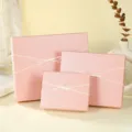Detailed view of elegant pink gift boxes with white bow tie, premium packaging texture. - Style 1 Gift Box / 18.5x14.5x5.5cm / Pink