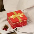 Detailed view of a square red gift box with gold bow and star pattern, elegant festive decor. - Small Size 12x12x7.2cm / Red