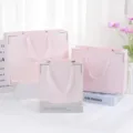 Pink paper gift bags with ribbon handles and gold trim, ideal for cosmetic and holiday packaging. - Pink Envelope Style