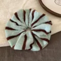 Detailaufnahme eines grün-braun gestreiften Strick-Haargummis mit weicher Wolltextur. - Blau und Kaffee Streifen