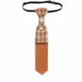 Closeup of retro brown plaid tie featuring sparkling rhinestone brooch and elegant pearl chain tassels. - Caramel Brown