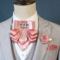 Gedetailleerd overzicht van de roze satin ascot broche, reversbloem en pochetset. - 3-delige set in lotusroze