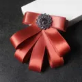 Red ribbon bow tie brooch with sparkling crystal center for formal suits and professional wear. - Brick Red