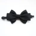 Detailed close-up of a classic black striped bow tie with adjustable elastic strap for kids. - Black