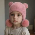 Detalle de gorro de punto para niños, gorro rosa de invierno con orejas de oso y pompones. - Rosa