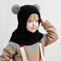 Detalle de primer plano de un gorro infantil de punto suave con orejas de pompón. - 2-6 Años / Negro