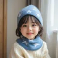 Primer plano de un acogedor conjunto de gorro y bufanda de punto azul para niños con estrellas. - Talla única / Azul cielo