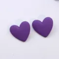 Detail view of stylish purple matte heart acrylic stud earrings, simple geometric design. - Purple