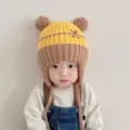 Detalle del gorro de punto para bebé con orejeras en amarillo y marrón con un osito tierno. - Adecuado para niños de 1 a 5 años / Amarillo