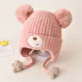 Lindo gorro de punto de invierno para bebé con orejeras y doble pompón suave en color rosa tierno. - Talla única / Rosa