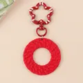 Gros plan sur le porte-clés anneau tressé fermoir fleur couleur bonbon rouge minimaliste - Rouge