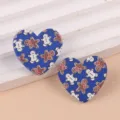 Detalle de pendientes de acrílico azul en forma de corazón con simpáticos hombres de jengibre. - Galleta Azul
