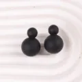 Detailaufnahme von mattschwarzen Doppelball-Ohrringen, minimalistischer Acrylschmuck. - Schwarz