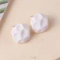 Primer plano de pendientes de botón geométricos blancos con textura de roca facetada. - Blanco