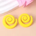 Close-up detail of bold yellow swirl acrylic stud earrings, unique candy color geometric style. - Yellow