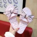 Nahaufnahme rosa Satin Schleife Pantoletten mit Stickerei und funkelndem Anhänger. - S (35-36) / Rosa + Rosa Schleife
