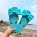 Detailansicht der stylischen Damen Pailletten Schleife Zehentrenner für Strand und Sommer. - M (EU 38-39) / Blaue Sohle