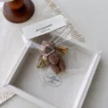 Cute pearl teddy bear keychain and bag charm with gold wings, soft plush pendant accessory. - Coffee Curly Bear Wing Pendant