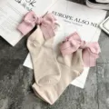 Detail view of sweet Japanese style beige cotton socks featuring large pink stitched bows for women. - One Size / Khaki + Pink Bowknot