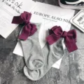 Close-up detail of cute grey cotton socks featuring a large purple bow and rolled edge design. - One Size / Light Gray + Red Bowknot