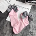 Detail view of pink cotton socks featuring large grey striped bows for a sweet style. - One Size / Pink + Gray Bowknot