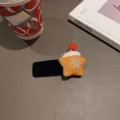 Detailansicht einer süßen Weihnachtsstern Haarnadel mit Plüschmütze und Schneeflocken. - Dunkelblauer Samt BB Clip mit Oranger Stern