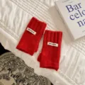 Rote gestrickte fingerlose Handschuhe Detailansicht, weiche Wollwärmer mit feiner Textur. - Einheitsgröße / Rot