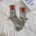 Chaussettes mi-hautes grises pour femmes avec étiquette smiley rouge, style streetwear. - Taille unique / Gris Clair