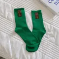 Groene geribbelde sokken tot halverwege de kuit voor dames met een schattige bruine smiley patch. - Eén maat / Donkergroen