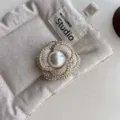 Elegant fabric camellia brooch with central pearl and gold trim, stylish clothing accessory. - Three-Petal Beige Brooch