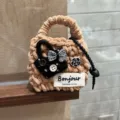 Handmade plush knitted mini earphone bag with cute bow and camellia pendant for daily use. - Chic Camel
