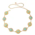 Vue détaillée de la chaîne de taille dorée bohème avec des motifs délicats et des turquoises. - Chaîne de Taille Turquoise Ovale Dorée