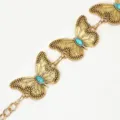Close-up detail van de gouden metalen taille ketting riem met turquoise vlinders. - Goud Turkoois Tailleketting
