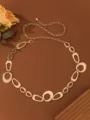 Closeup of gold metal chain belt, geometric rings and fine links detail for stylish dress decor. - Ring Waist Chain / Gold