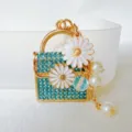 Closeup of a cute mini rhinestone daisy handbag keychain pendant with pearls and tassel detail. - Daisy Handbag Blue