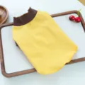 Close-up detail of the yellow pet base shirt featuring a stylish contrast brown rolled mock neck. - XS / Yellow