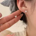Gros plan détaillé de boucles d'oreilles cœur en argent S925 avec bord perlé délicat. - Style Cœur Poli (Argent) / Argent