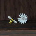 Gros plan détaillé de boucles d'oreilles asymétriques abeille marguerite en argent. - Style Fleur d'Abeille Asymétrique (N15) / Argent 925 / Or blanc