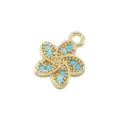 Detailed close-up of a golden five-petal flower pendant with turquoise inlay and beaded texture. - Gold With Turquoise Style